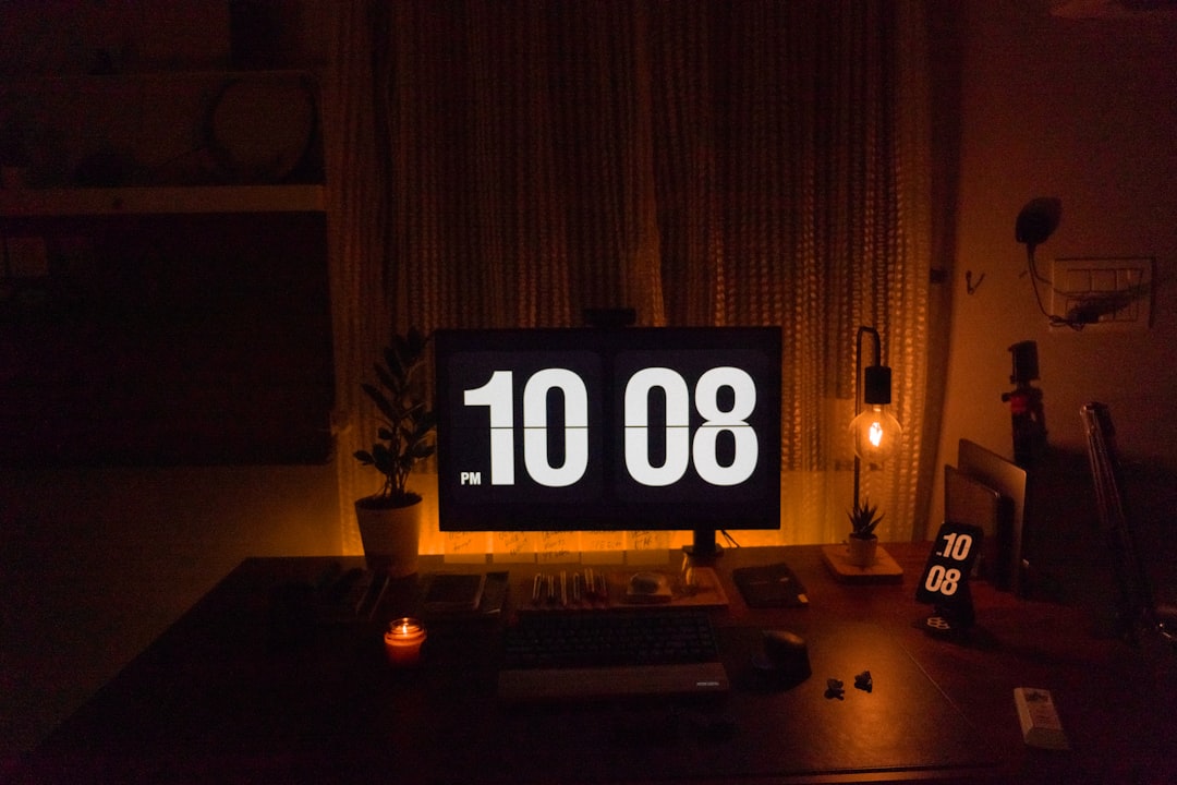 a desk with a computer and a clock on it