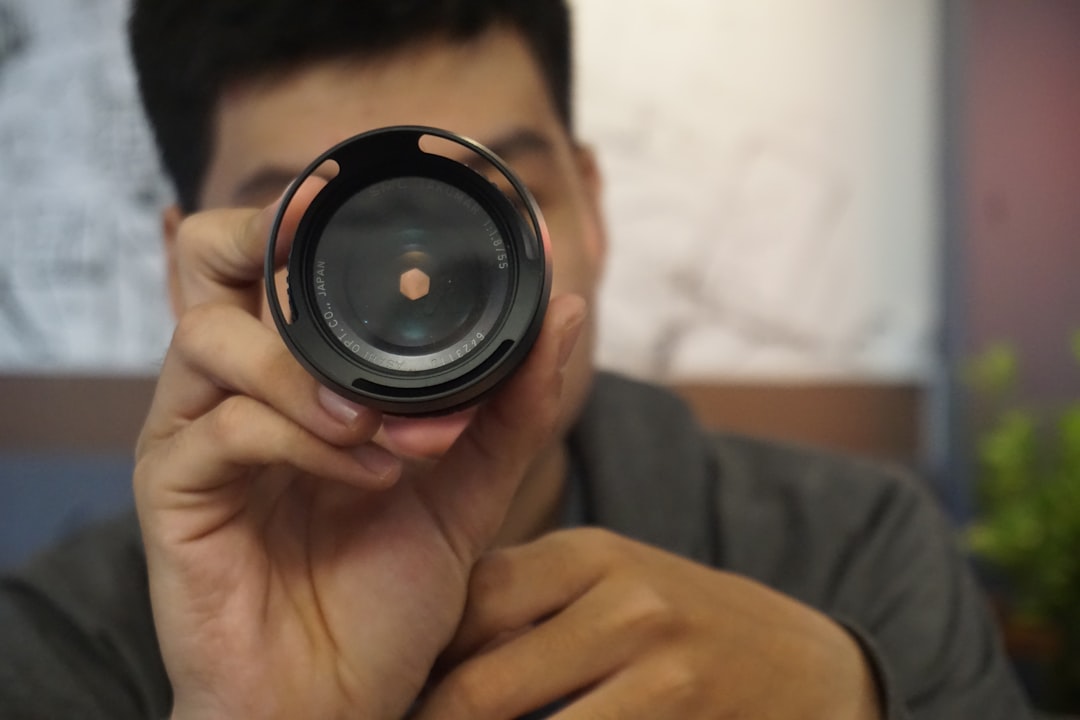 person holding black camera lens