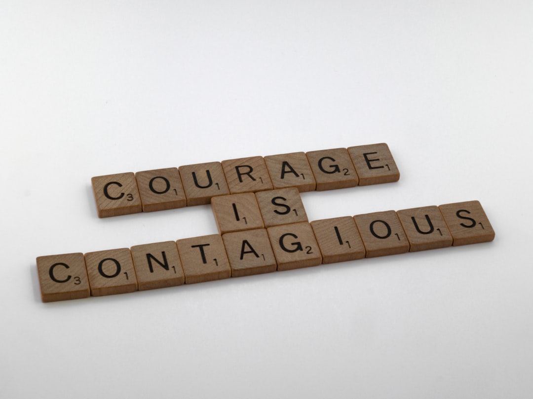 scrabble tiles spelling out the words courage is contagious