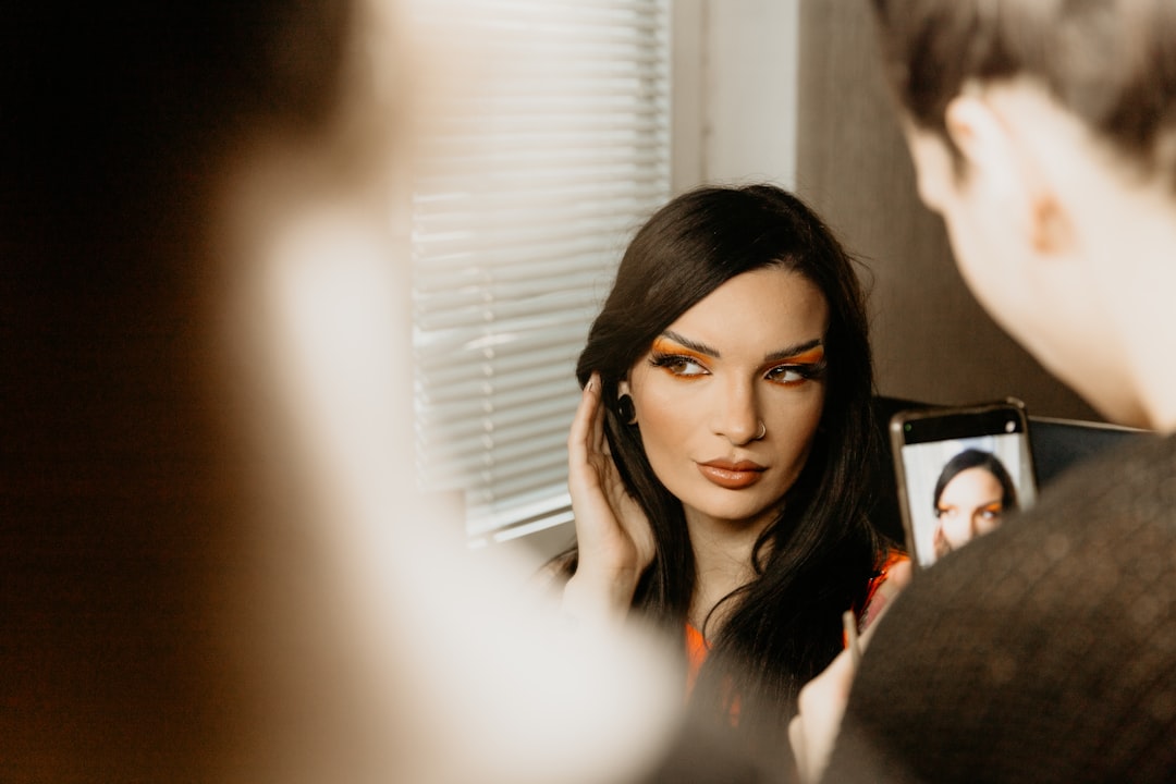a woman is looking in a mirror with her face painted