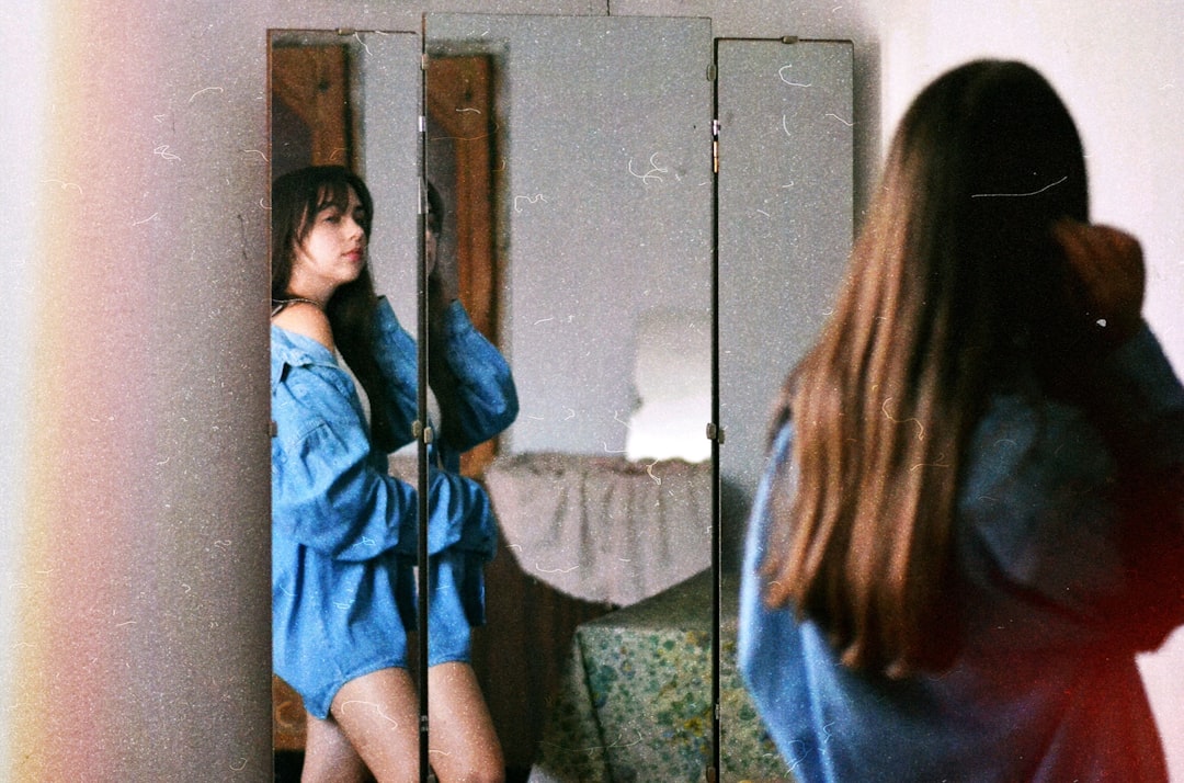 woman in blue jacket standing near mirror