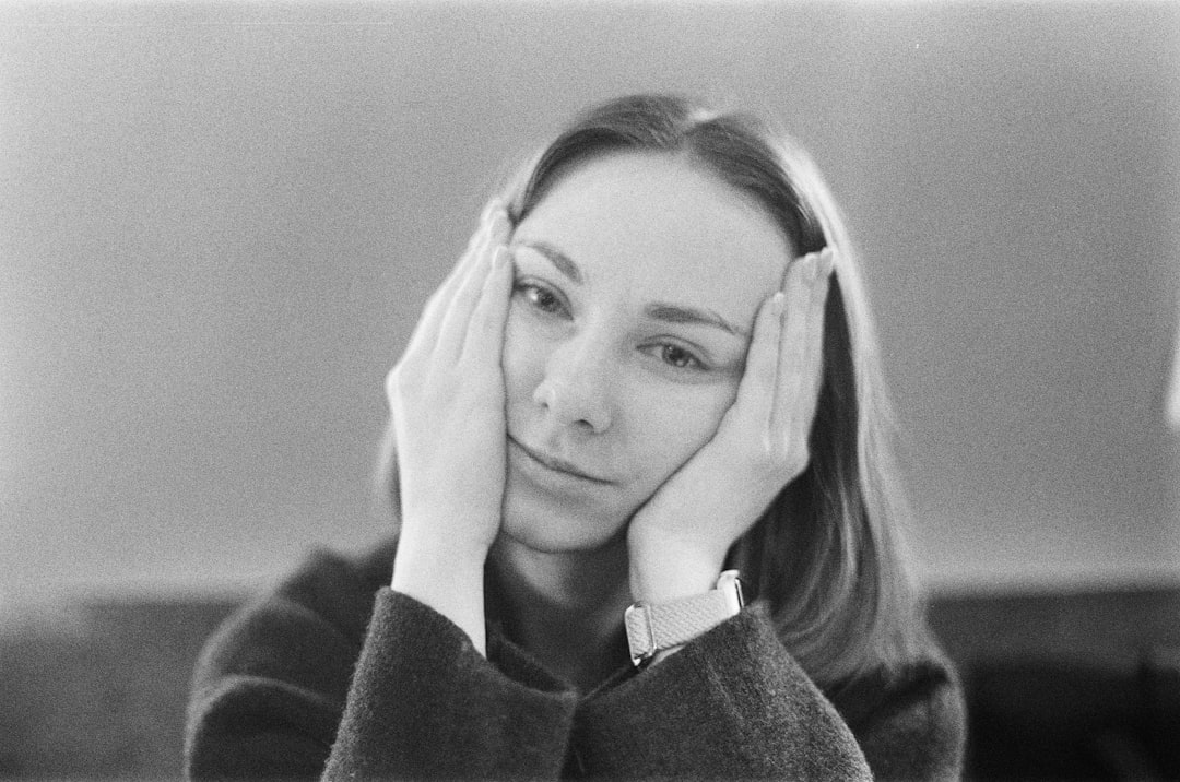 A woman rests her face in her hands.