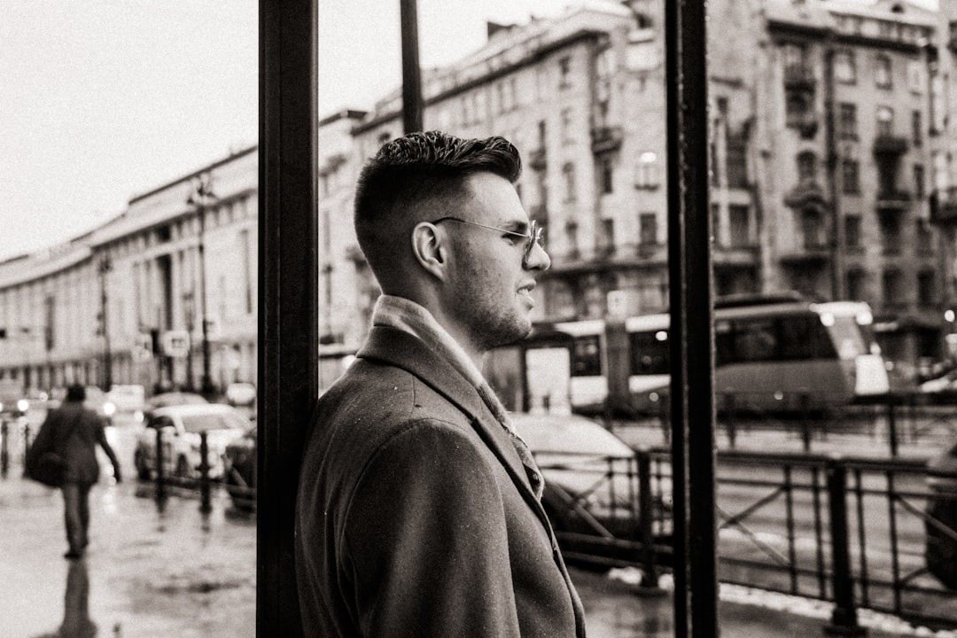 man in black coat standing near window
