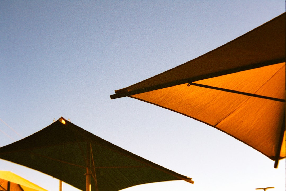 Two large sunshades against a clear blue sky