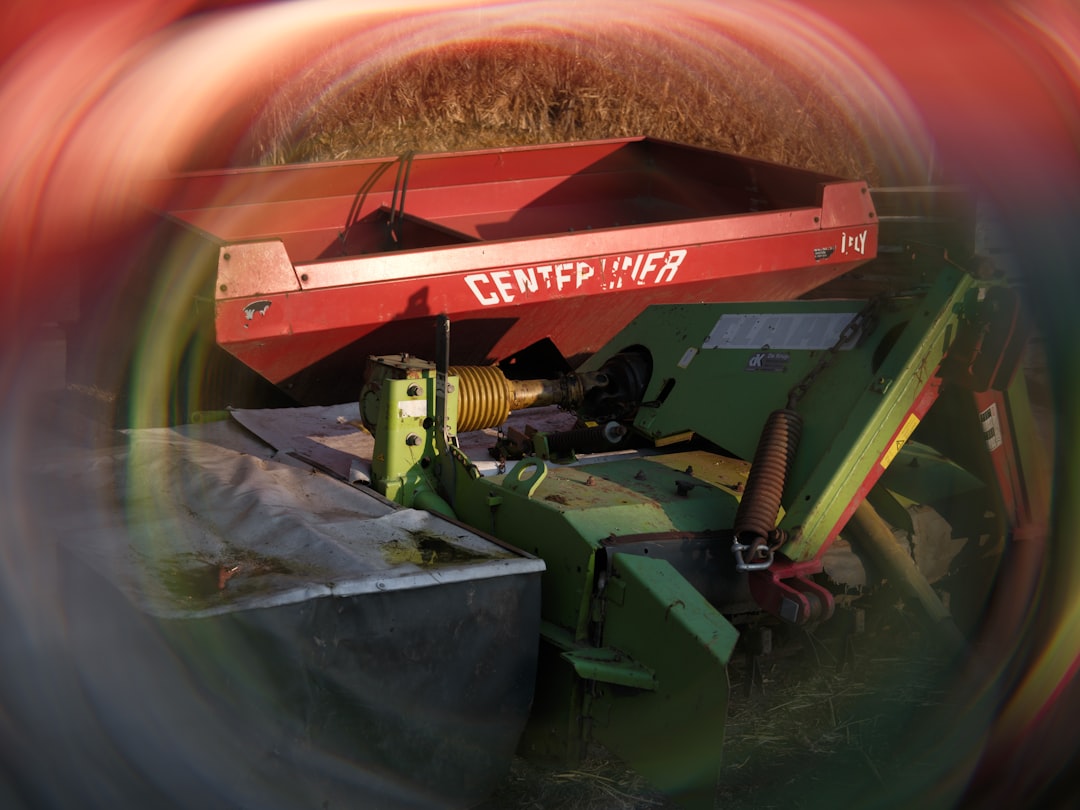 Red and green agricultural mower with text