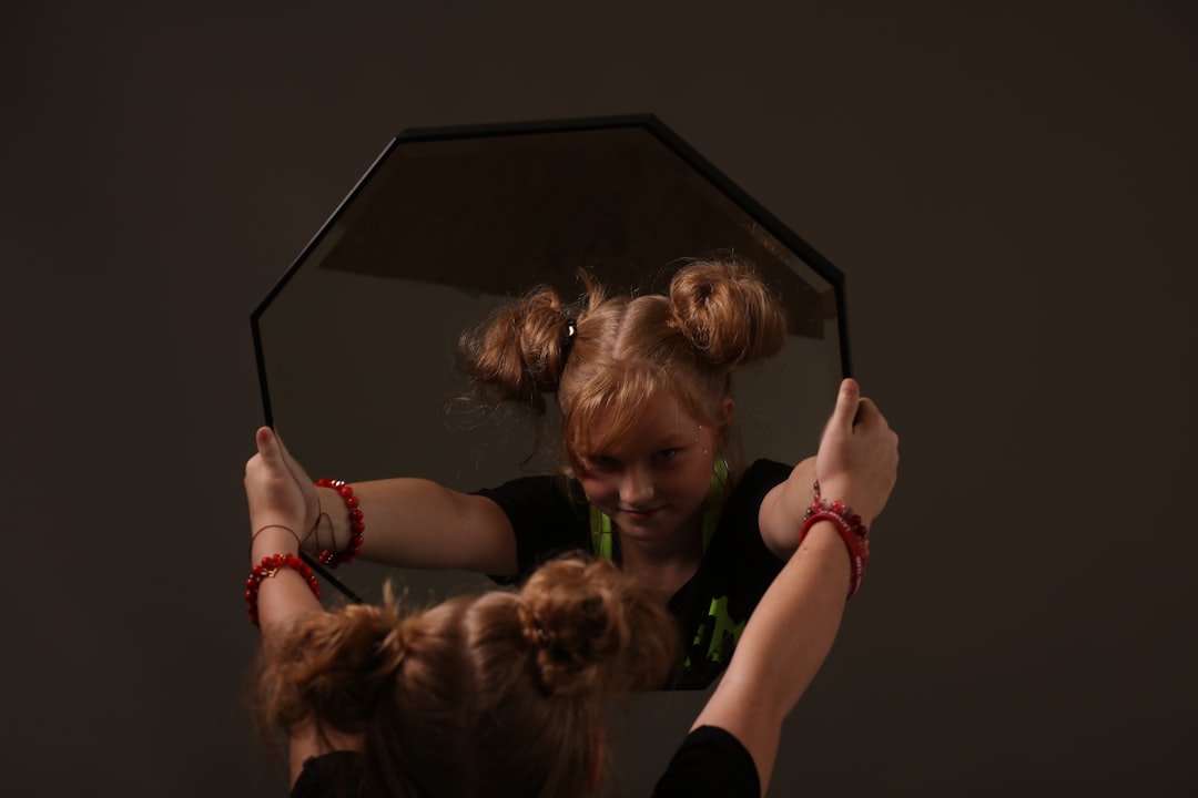 A woman holding a mirror with her hair in it